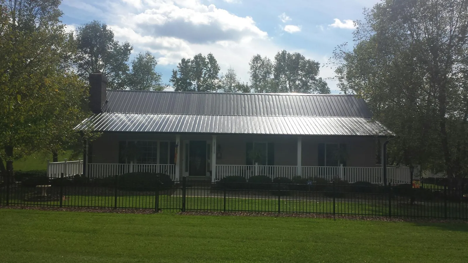 Gray metal roof on a brick ranch with a full width front porch — Gutter Guard Installation work by our crew in Lengby