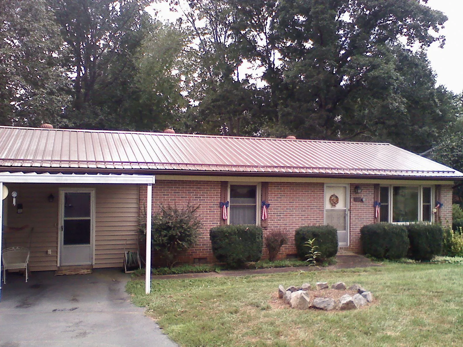 Bronze metal roof and carport on a brick ranch home — Roof Repair work by our crew in Lengby